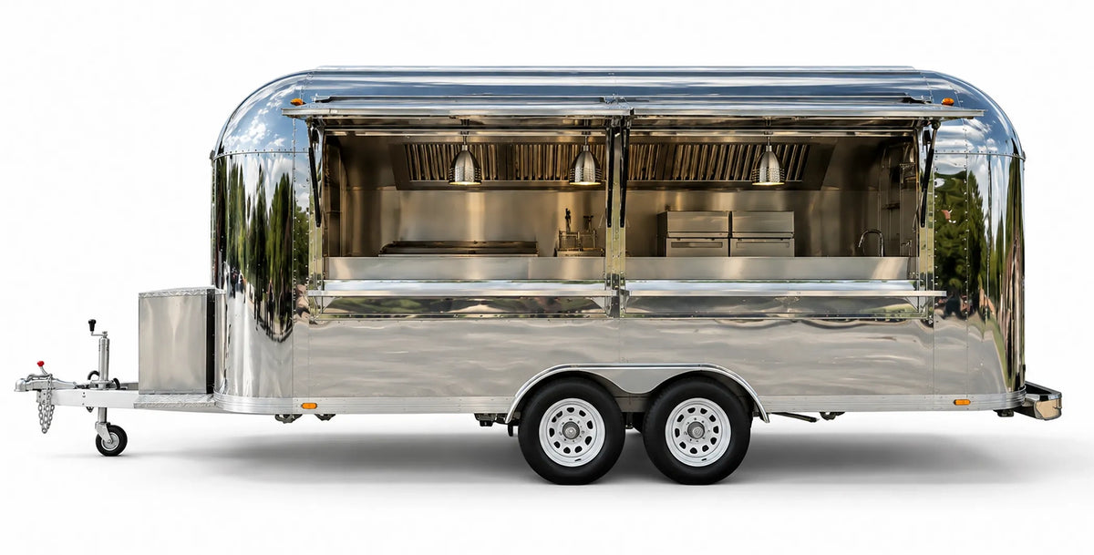 Polished chrome Airstream style food trailer with dual open serving windows and commercial kitchen fitout